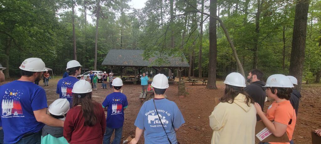 4-H Forestry team waring hard hats in a wooded park.